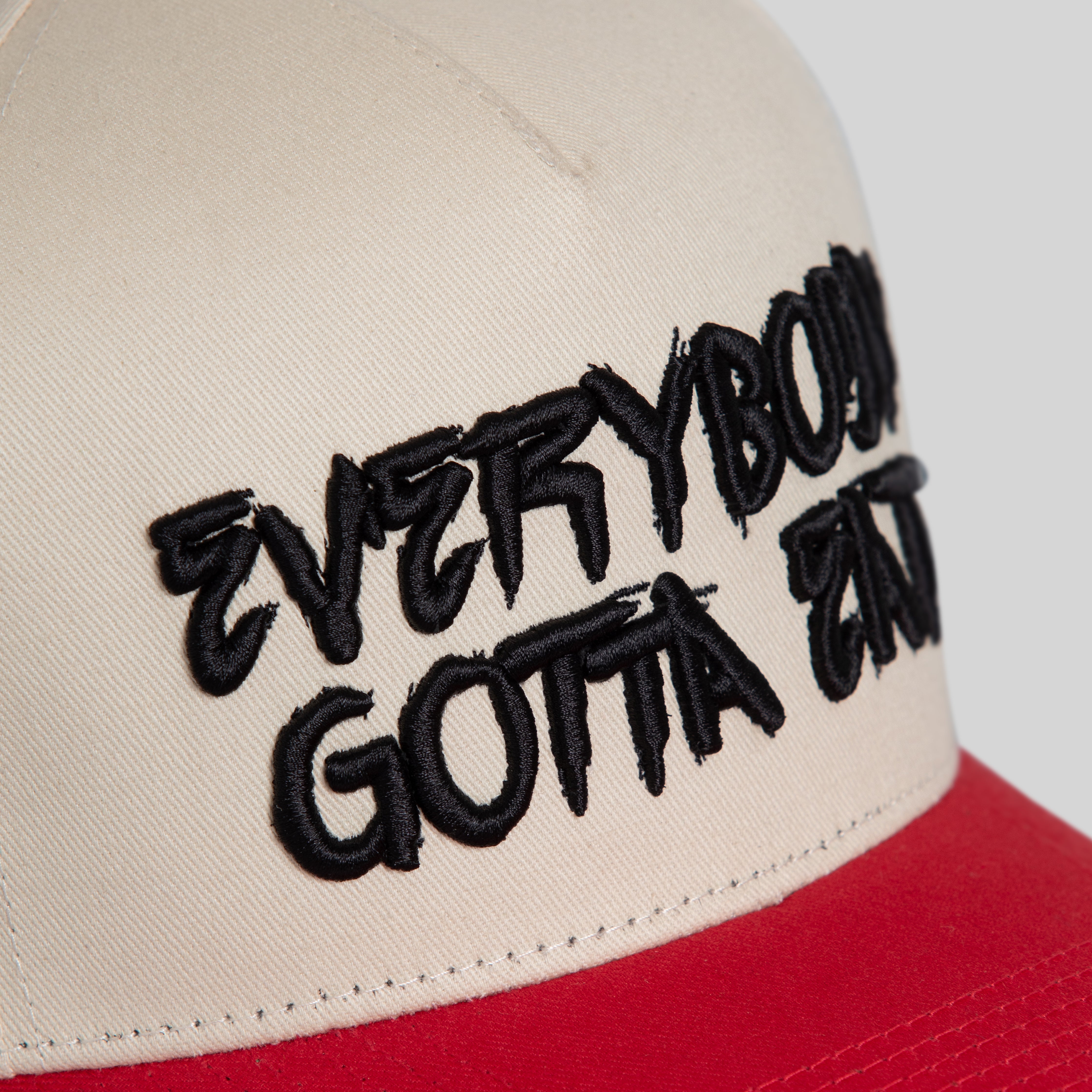 EVERYBODY GOTTA EAT SAND RED TWILL TRUCKER