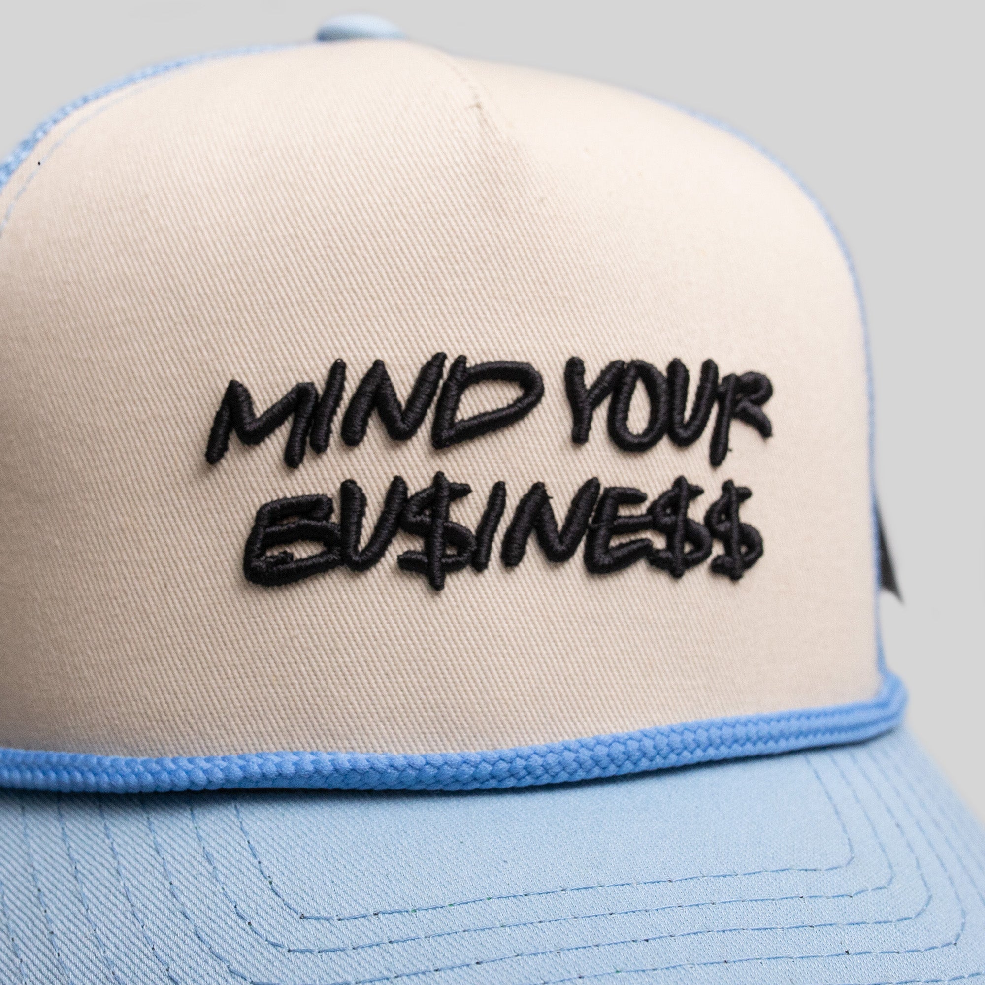 MIND YOUR BUSINESS SAND/UNI BLUE TRUCKER HAT