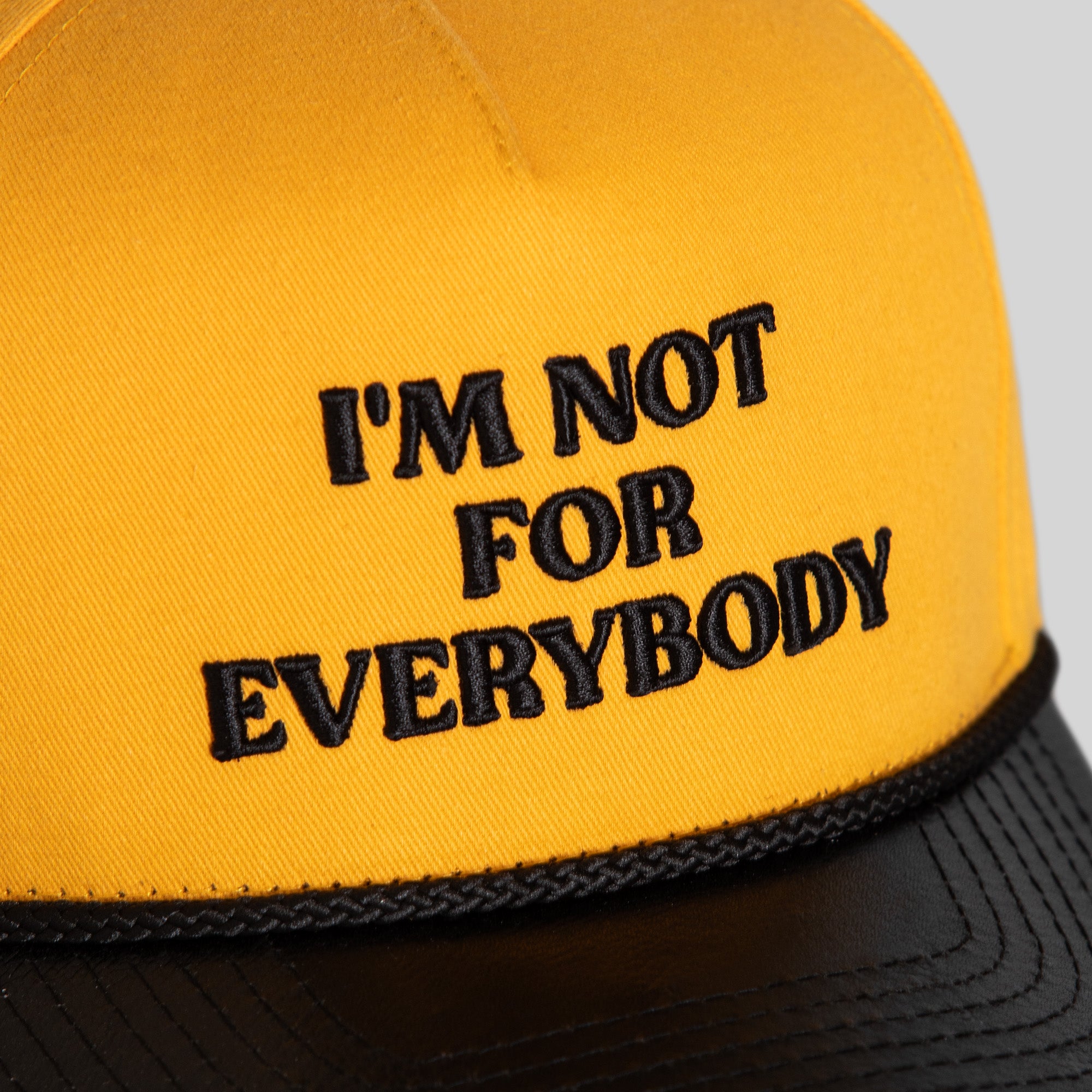I'M NOT FOR EVERYBODY YELLOW GOLD BLACK TWILL LEATHER TRUCKER