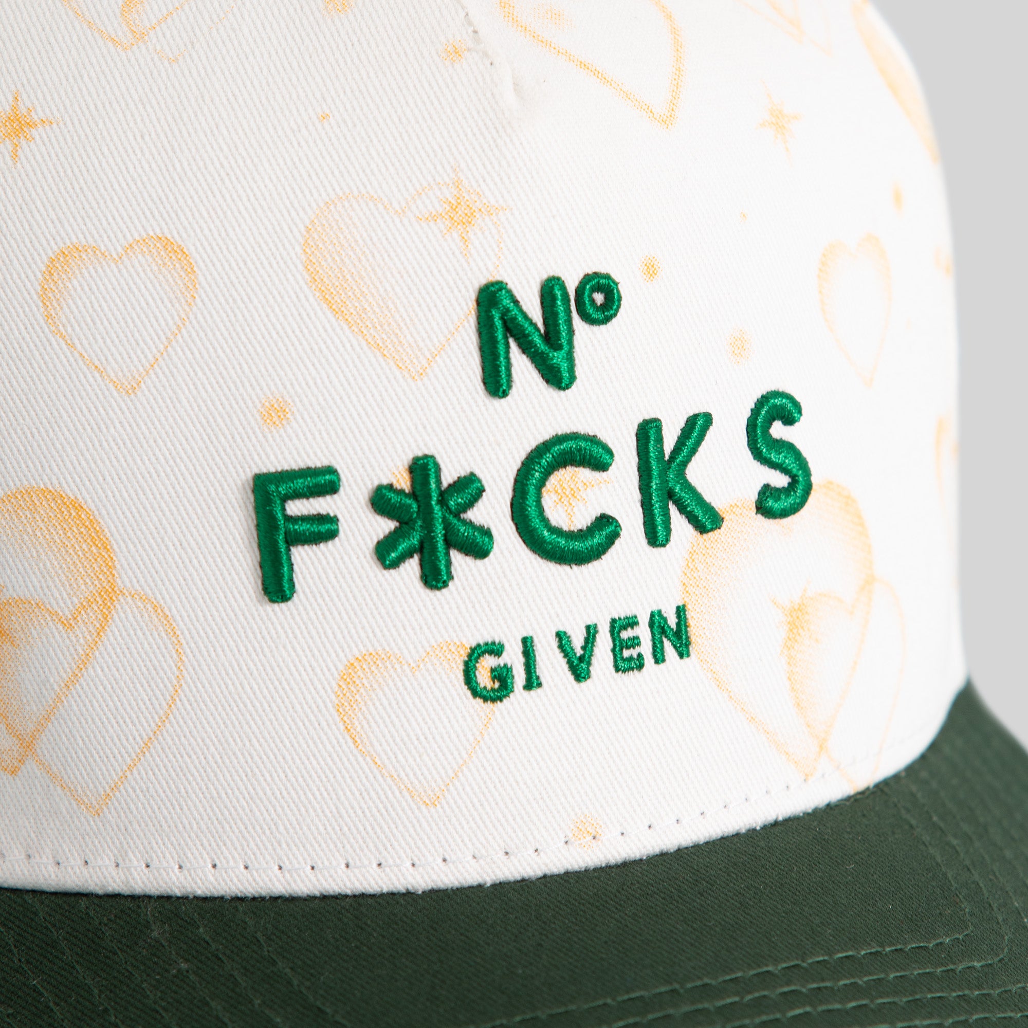 NO F*CKS GIVEN MAJESTIC HEARTS OFF WHITE EMERALD TWILL TRUCKER
