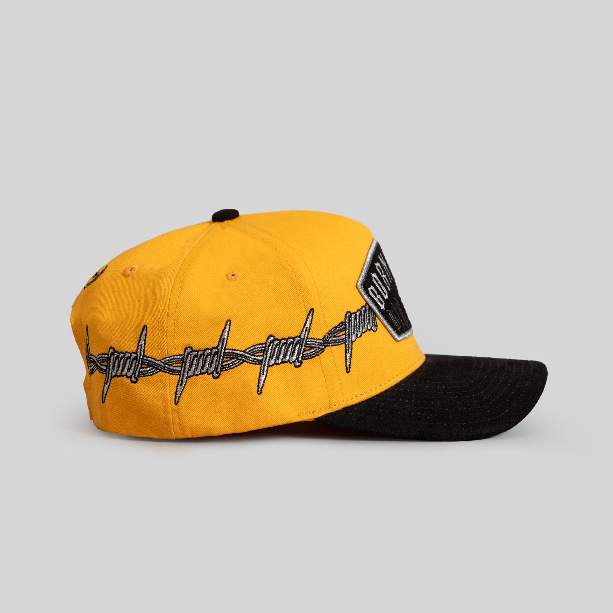 BORN ALONE BARBED WIRE GOLD BLACK TWILL SUEDE TRUCKER