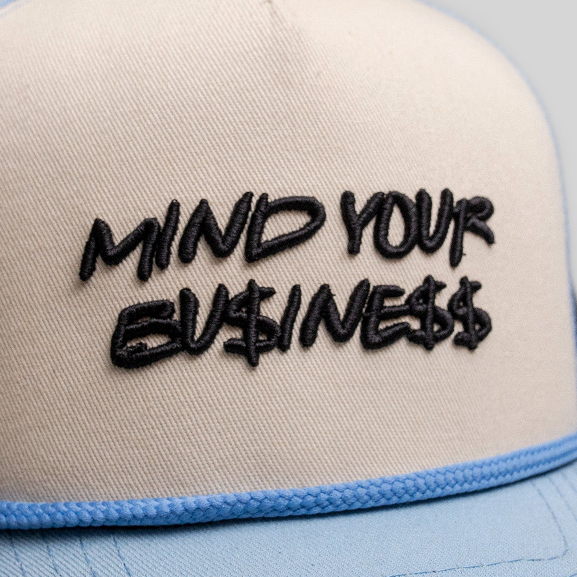 MIND YOUR BUSINESS SAND/UNI BLUE TRUCKER HAT